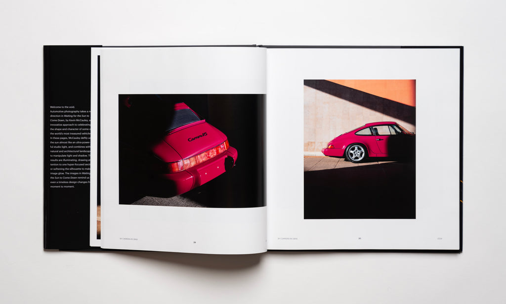 Inside spread of the automotive photography book Waiting For The Sun To Come Down by Kevin McCauley, open to images of a ruby red Porsche 911 Carrera RS with stunning shadows. Published by Carrara Media.