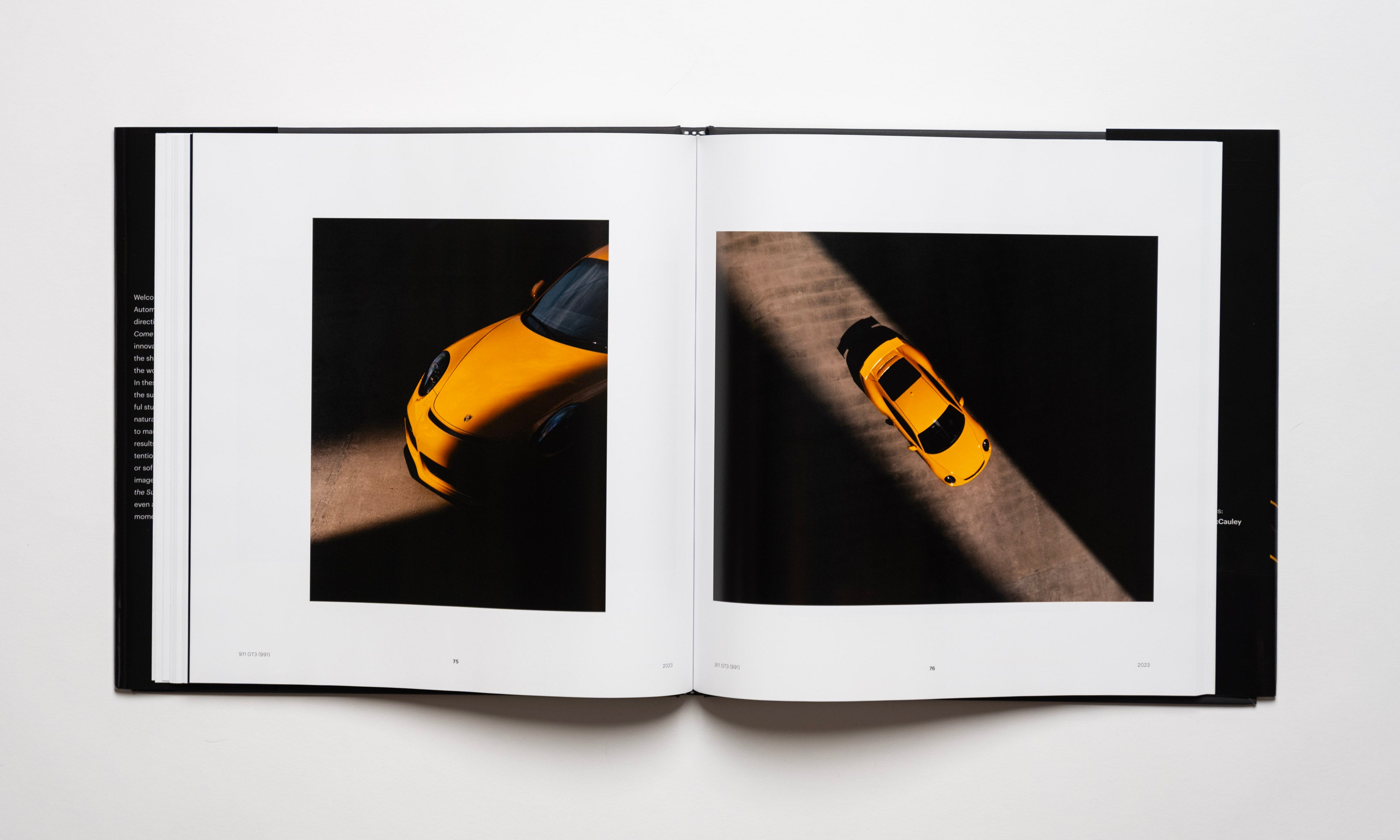Inside spread of the automotive photography book Waiting For The Sun To Come Down by Kevin McCauley, open to images of a yellow Porsche 911 GT3 with stunning shadows. Published by Carrara Media.