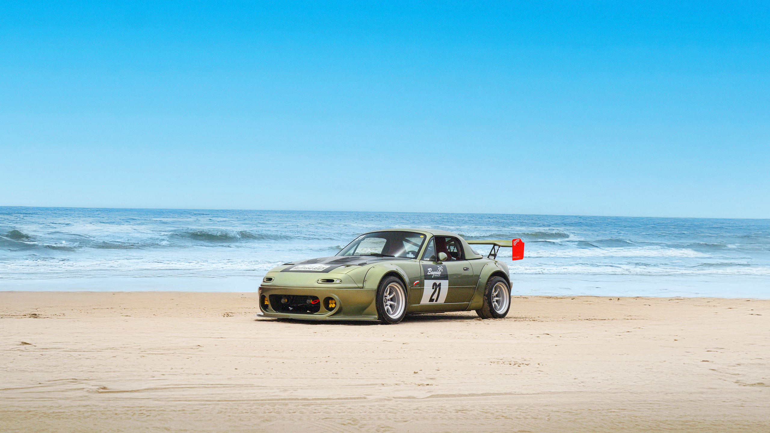 A custom-built Mazda Miata racecar parked on the beach in Southern California, in an image from Bayside Magazine Issue 01, a new periodical celebrating coastal car culture. Published by Carrara Media.