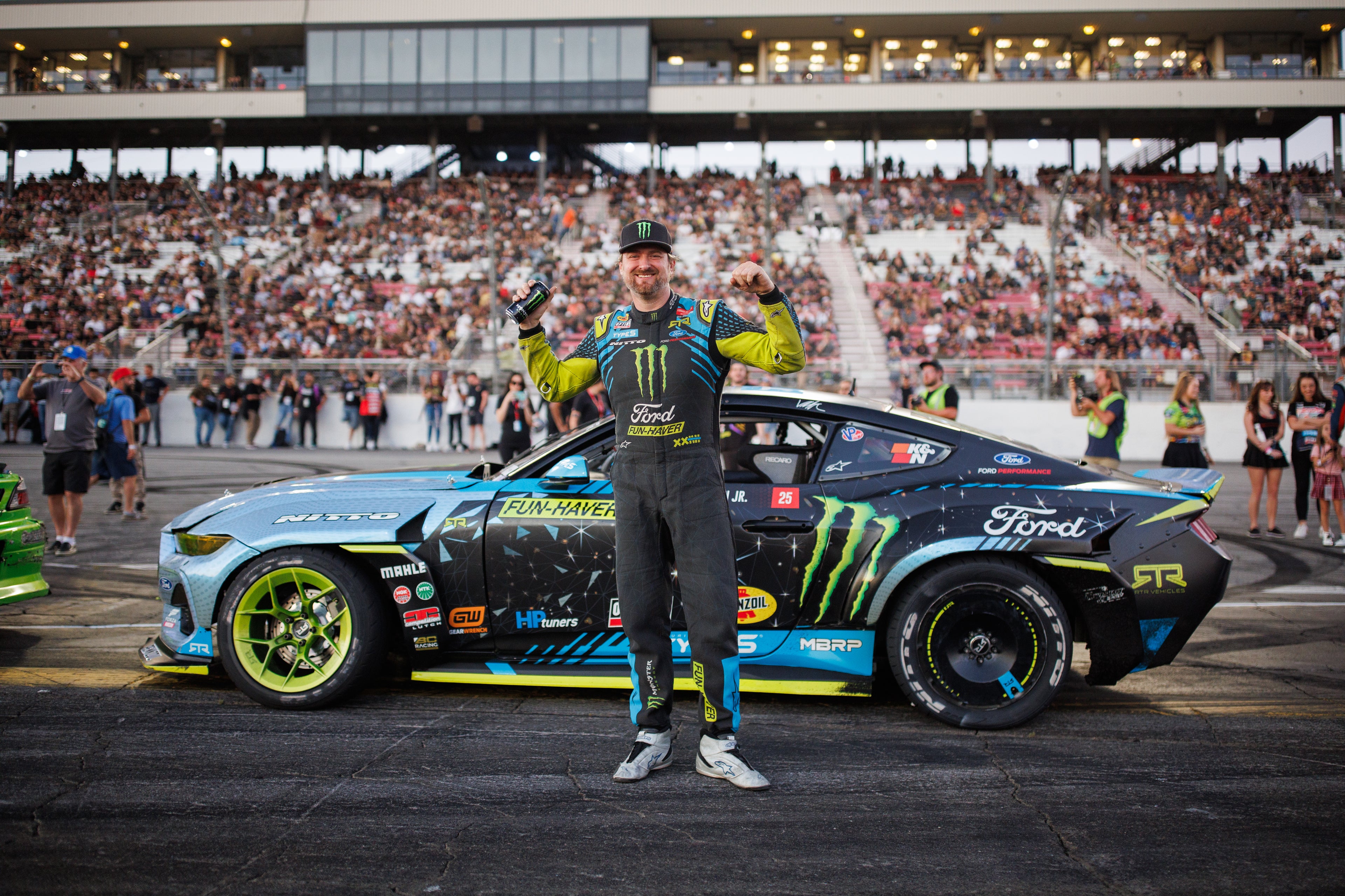 Image of Vaughn Gittin Jr. posing in front of his Ford Mustang RTR FD drift car during a Formula Drift event, photo by Larry Chen. From the new book Ready To Rock by Vaughn Gittin Jr. with Mike Spinelli, foreword by T-Pain, published by Carrara Media. The story of RTR Vehicles and professional drifting, off-road racing and the Ford RTR Mustang and RTR Bronco.
