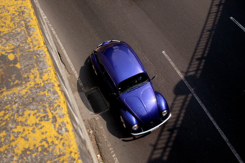 Image of a purple Volkswagen Beetle overhead as it heads into a tunnel in Mexico City, from the new book Vochos Unidos by Rodrigo Gaya Villar, published by Carrara Media. A coffee table book of automotive photography showing the Volkswagen Beetle across Mexico, aka "El Vocho." Limited Edition with slipcase and Leen Customs pin available for 500 copies only.