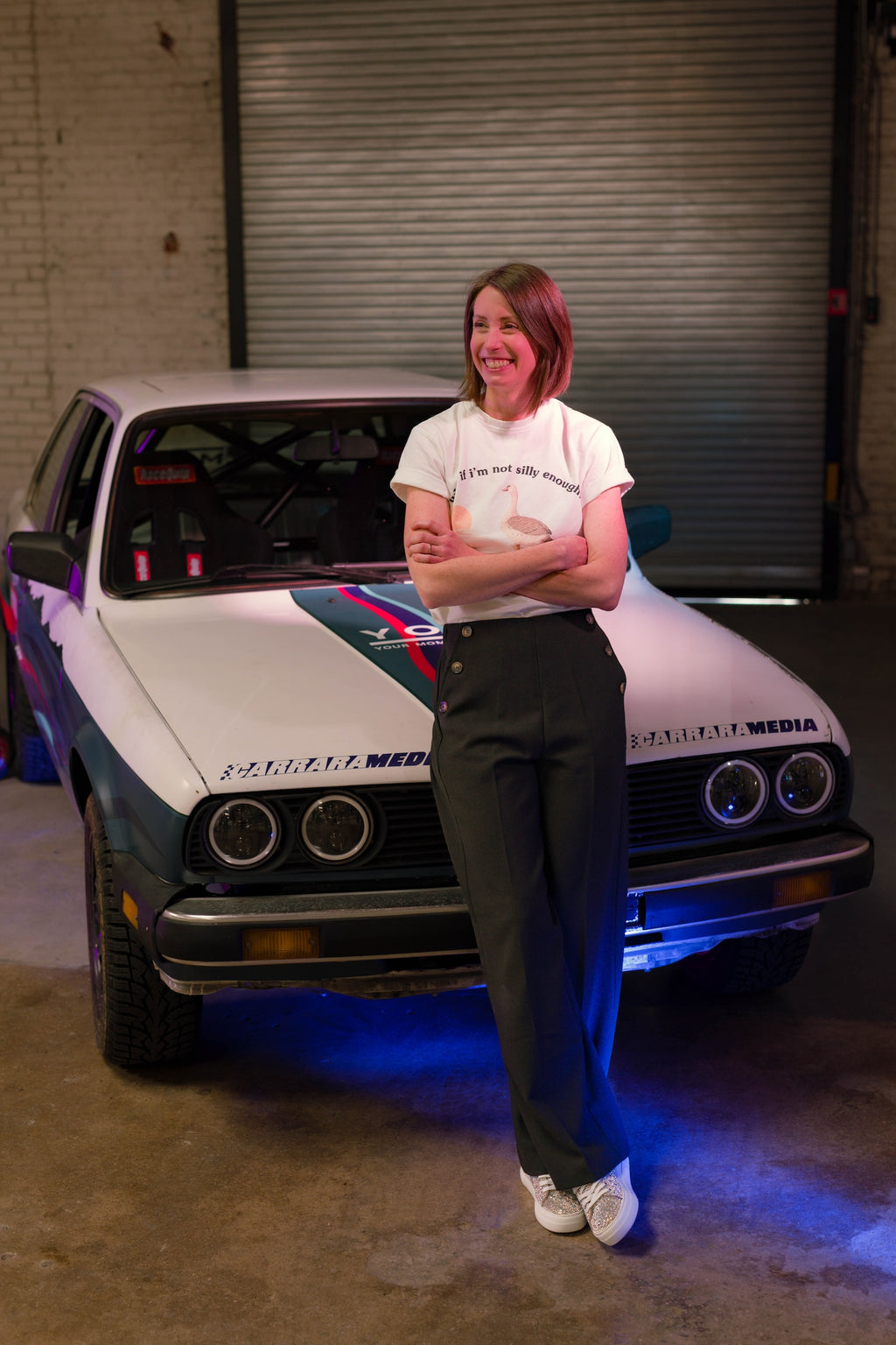 Image of Your Mom Races Rally author Kelly Conroy posing with her BMW E30 rally car named “Nessie.” From the book Your Mom Races Rally, A nonfiction rally racing memoir describing Conroy’s inspiring journey to become a racecar driver to confront her depression after motherhood. Published by Carrara Media.